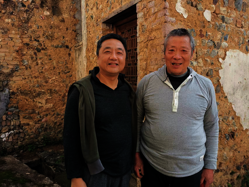 美术学院胡俊副教授（左）与嵩溪村村民在一起